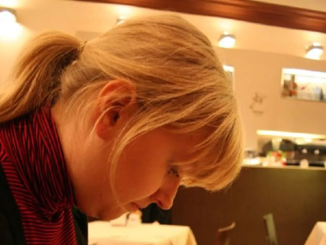 In the image we can see there is a woman who is sitting on chair and on table there is a book which...