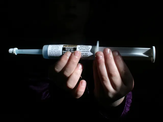 In this image a person's hands are visible. He is holding an injection which is having some text on...