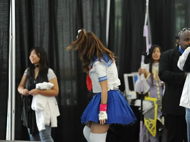 In this image there are a few people standing on the ground. Behind them there are curtains. There...