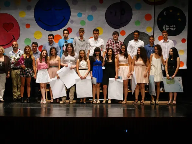 Here we can see group of people posing to a camera. They are holding papers and she is holding a...