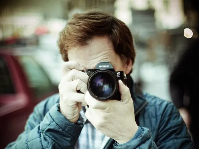 In this image there is a man who is taking the pictures with the camera. In the background there is...