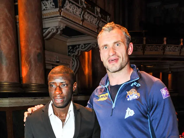 In this picture we can see two men standing here, a man on the left side wore a suit, we can see...